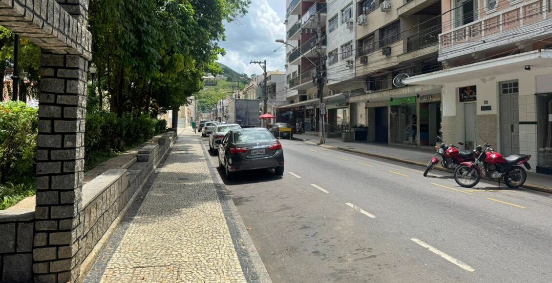 Rua tranquila com carros estacionados.